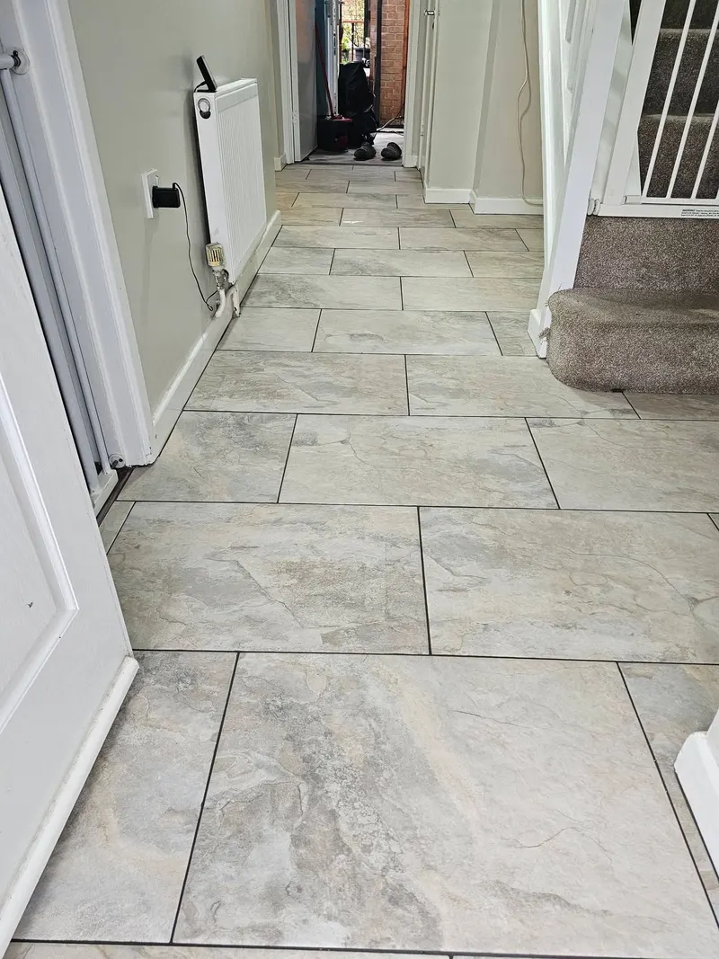 Large grey floor tiles laid along a hallway in Swansea