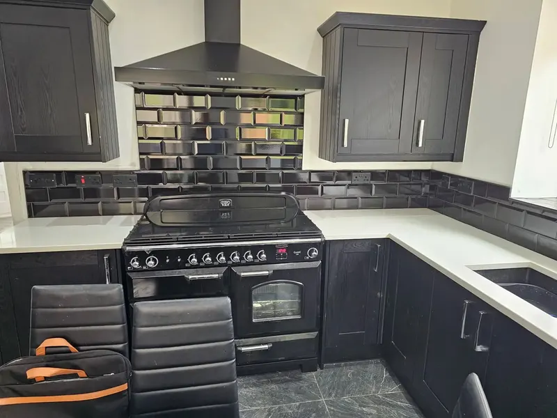 Black metro tile kitchen splashback behind a range cooker