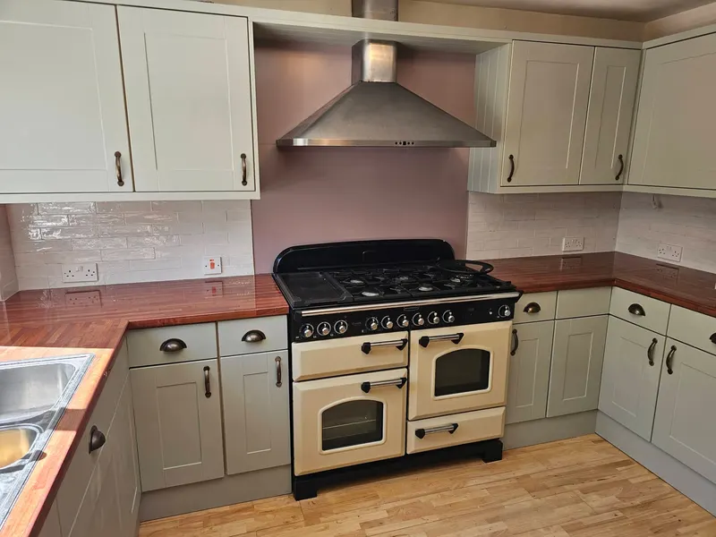 White brick-effect kitchen splashback behind a cream range cooker