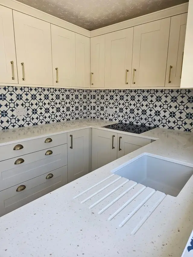 White kitchen with a blue and white patterned tile splashback