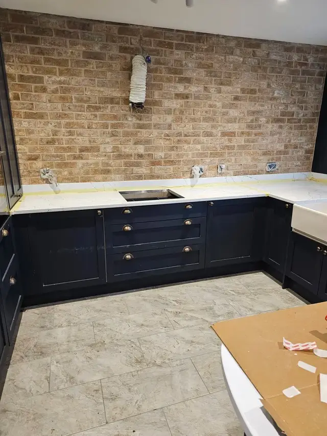 Natural stone brick-effect wall in a kitchen with a tiled floor