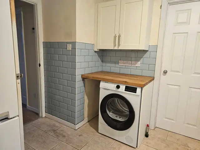 Bright blue brick-effect tiles above a washing machine